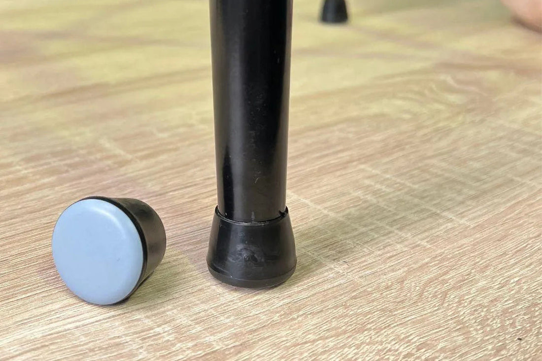 Gecko chair glides fitted to a black chair leg and shown separately with the smooth base exposed on timber flooring.